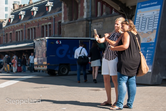 Two ladies friends taking a selfie at Amsterdam Central Station Street Photography